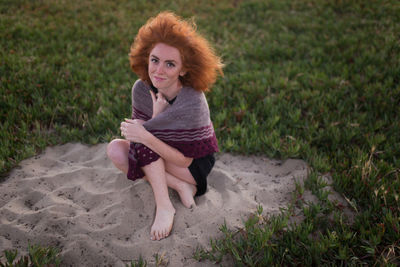 Portrait of young woman sitting on grass