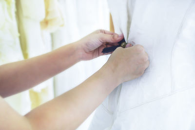 Close-up of woman holding hands on bed