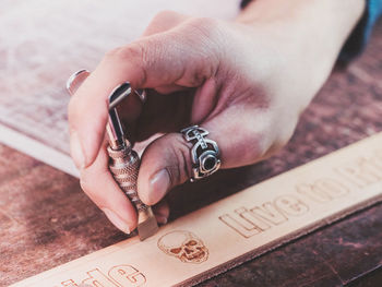 Close-up of hand holding text on table