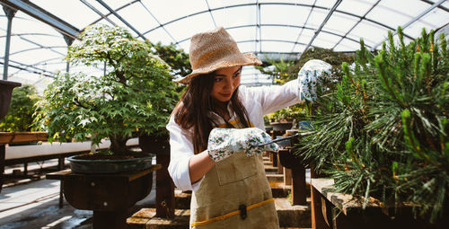 Woman working on table in greenhouse