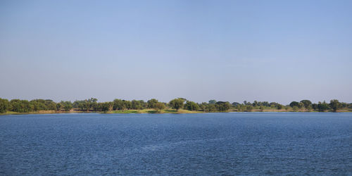 Scenic view of lake against clear blue sky