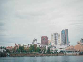 Scenic view of river by buildings against sky