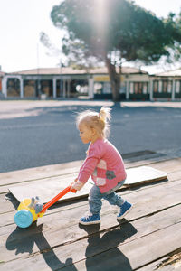 Full length of girl standing on footpath