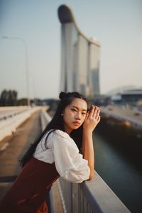 Portrait of woman standing against car