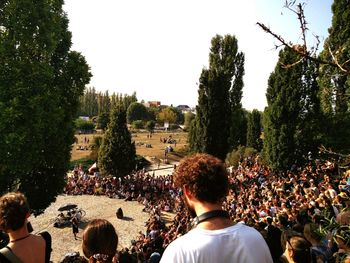 Rear view of people enjoying music concert against sky