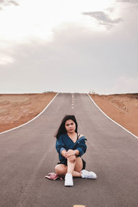 Portrait of woman sitting on road