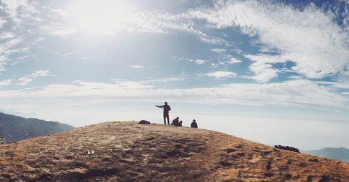 People on mountain against sky