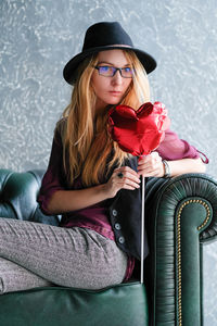 Portrait of beautiful young woman sitting in hat