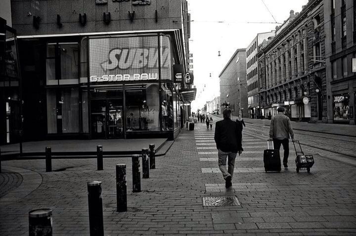 REAR VIEW OF PEOPLE WALKING ON STREET IN CITY