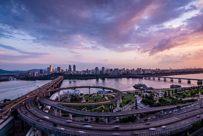 Aerial view of buildings in city at sunset