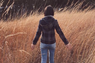 Rear view of woman standing on field