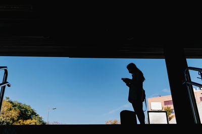 Silhouette man photographing against sky