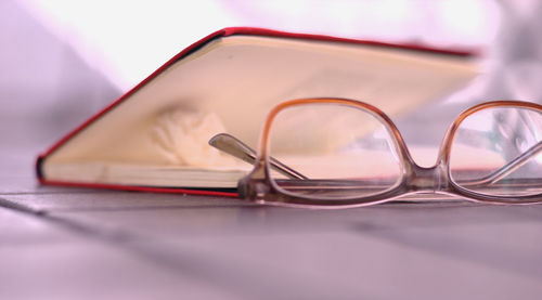 Close-up of eyeglasses and book on table