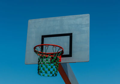 Low angle view of basketball hoop against clear blue sky