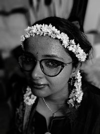 Close-up portrait of smiling young woman wearing flowers