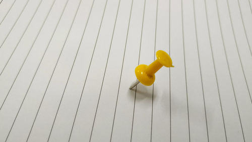 High angle view of yellow toy on wooden floor
