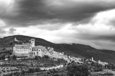 Built structure on landscape against cloudy sky