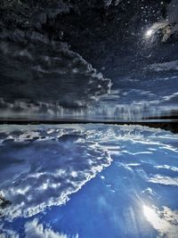 Scenic view of lake against sky at night