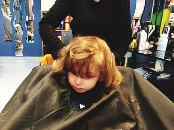 Midsection of barber preparing girl for haircut