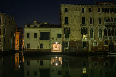 Reflection of old building in water at night
