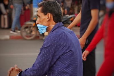 Side view of man looking at city street