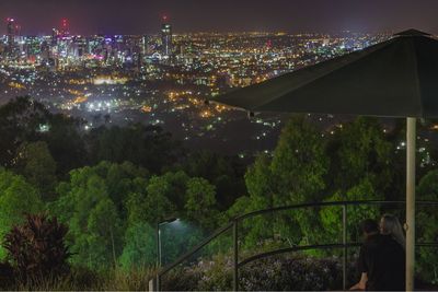 Illuminated cityscape against sky at night