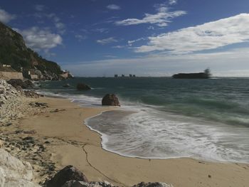 View of beach against cloudy sky