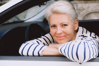 Portrait of young woman sitting in car