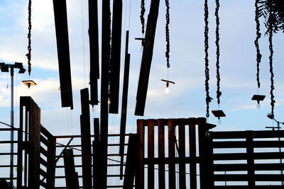 Close-up of bird perching on pole against sky