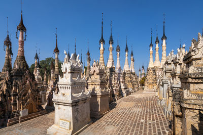 Panoramic view of temple amidst buildings against blue sky