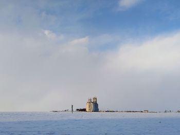 Lighthouse by sea against sky