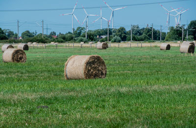 Hay bales on field against sky