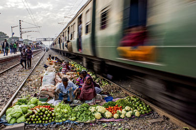 View of market vendors sitting on railroad track