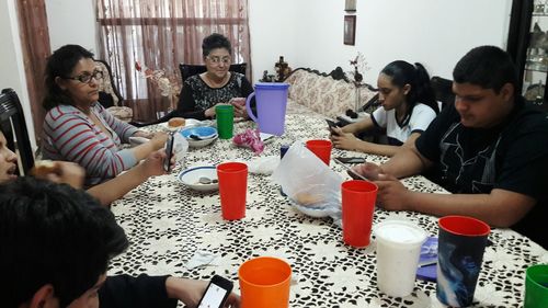 Friends sitting on table at home