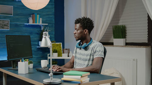 Young man using computer by table