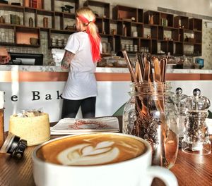 Rear view of woman with coffee cups