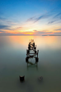 High angle view of broken pier over sea during sunset