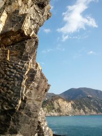 Rock formations by sea against sky