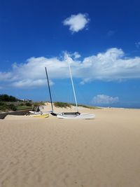 Sailboat on beach against blue sky