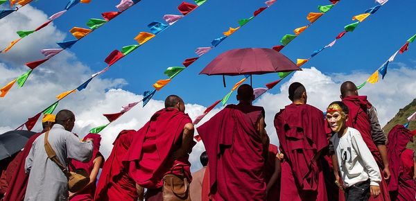 Rear view of people in traditional clothes against sky