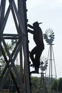 Side view of man holding umbrella against sky