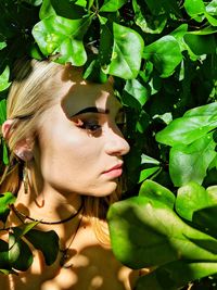 Close-up portrait of young woman with leaves