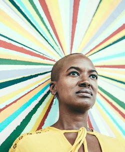 Low angle view of mature woman against colorful painted wall