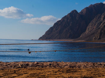 Scenic view of sea and mountains against sky