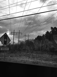 Road sign against cloudy sky