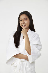 Portrait of a smiling young woman against white background