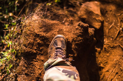 Low section of man standing on rock