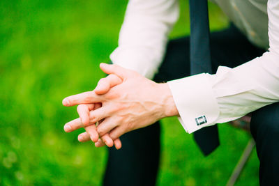 Midsection of man hand on field