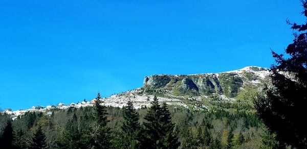 Low angle view of mountain against clear blue sky