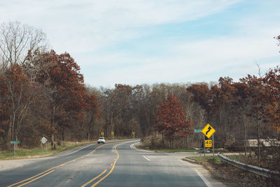 Road amidst trees against sky